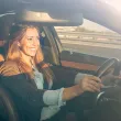 Femme souriante qui conduit une voiture