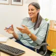 Une femme assise à un bureau, parlant au téléphone.