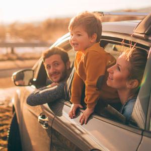 un homme une femme et un enfant sortent leur tête par les vitre de leur voiture