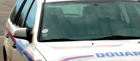 Une voiture de douane est garée à l’extérieur 