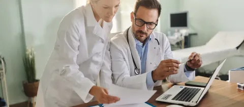 Une femme et homme médecin en train de regarder un document médical.