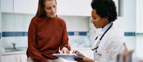 Médecin et patiente examinant un document, consultation médicale.