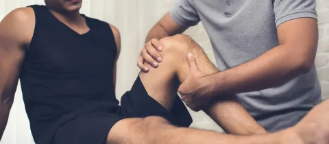 Thérapeute aidant un patient avec un exercice de physiothérapie du genou.