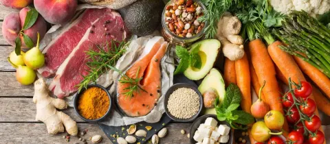 Vue de dessus d'une sélection d'aliments sains&nbsp;: viande, poisson, légumes, fruits, noix et huiles.