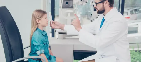 Ophtalmologiste examinant la vision d'une jeune fille.