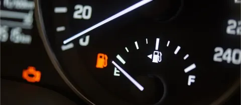 Tableau de bord de voiture avec l'indicateur de niveau de carburant presque vide.