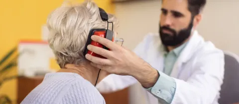 Un professionnel de santé équipe un patient pour un test d'audition.