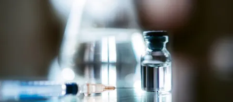Une seringue et un flacon en verre, prêts pour une injection.