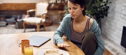 Une femme face à son repas semble ne pas vouloir manger.