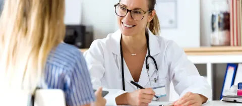 Une femme médecin souriante s'entretient avec sa patiente.