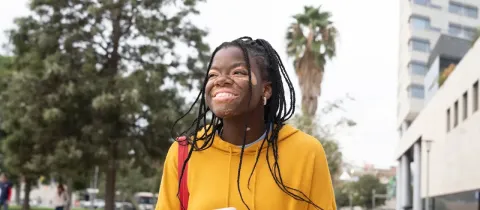Jeune femme atteinte de vitiligo, souriante, utilisant son téléphone.