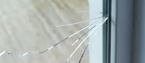 Gros plan sur une vitre brisée, montrant les fissures partant d'un point d'impact. (Image identique à 368.jpg)