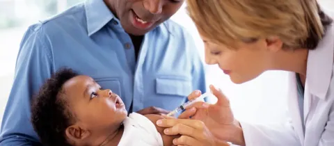 Un professionnel de santé administre un vaccin à un bébé.