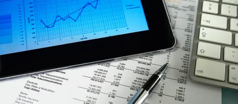 Analyse de documents financiers avec ordinateur portable.