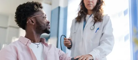 Un médecin prend la tension d'un patient dans la cadre d'une visite médicale.