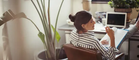 Femme utilisant un ordinateur portable à domicile.