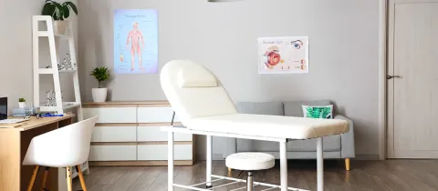 Bureau médical avec une chaise blanche et un bureau, créant un environnement professionnel et accueillant