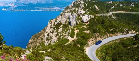 une route au sein de montagnes en bord de mer