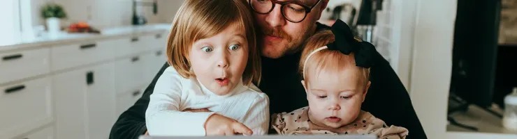 Père avec ses deux enfants regardant la tablette