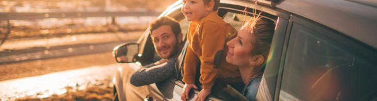 un homme une femme et un enfant sortent leur tête par les vitre de leur voiture