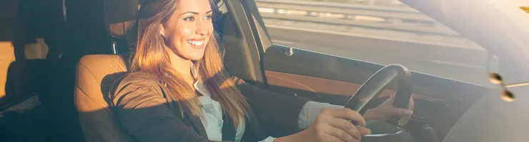 Femme souriante qui conduit une voiture