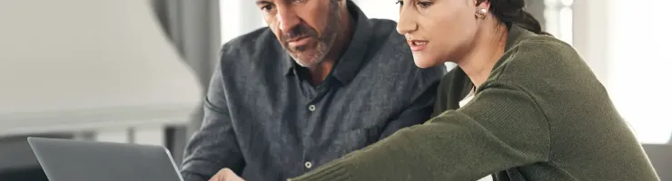 Couple regardant un ordinateur à la maison