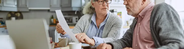 Couple senior consultant des papiers et l'ordinateur