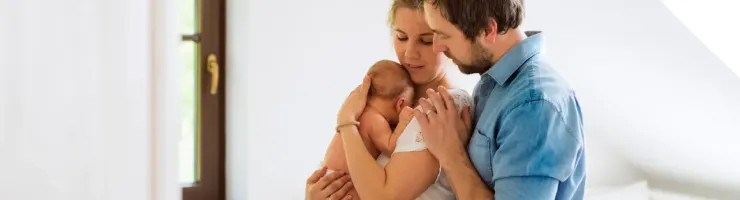 Un couple en train de passer du temps avec leur bébé, moment de soutien et de complicité.