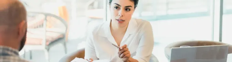Femme en train de tendre un document à quelqu'un.