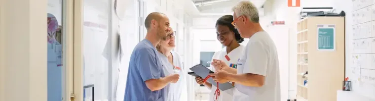 Du personnel médical discute ensemble dans un couloir de l'hôpital.