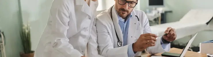 Une femme et homme médecin en train de regarder un document médical.