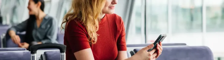 Une femme consulte son téléphone portable à l'aéroport.