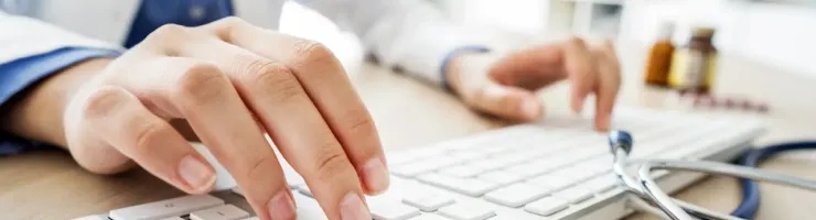 Mains de médecin tapant sur un clavier, travail de bureau et productivité.