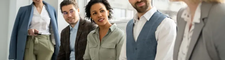 Groupe de collègues de travail en train d'écouter une collaboratrice féminine.