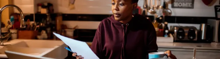 Une femme travaille sur un ordinateur portable dans une cuisine.