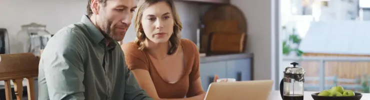 Couple en train de faire une recherche sur leur ordinateur portable.
