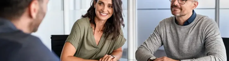 Homme travaillant à un bureau avec un ordinateur portable et documents.
