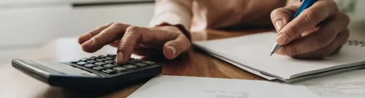 Gros plan montre des mains féminines utilisant calculatrice.