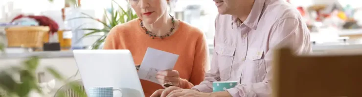 Un couple est en train de consulter des documents en utilisant un ordinateur portable.