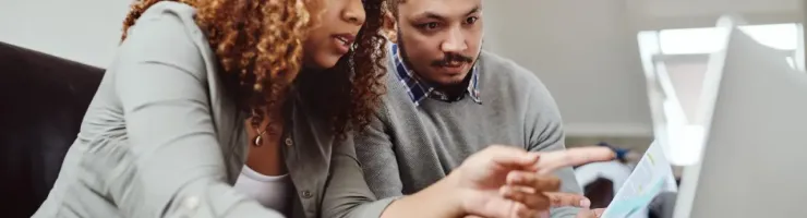 Un couple fait ses comptes en utilisant un ordinateur portable.