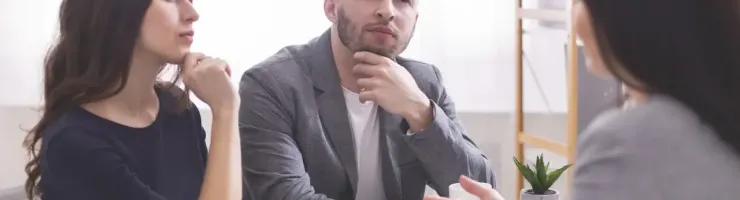 Un couple en train d'être conseiller par une femme.