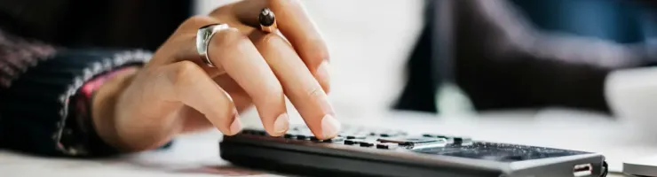 Gros plan montre des mains féminines utilisant calculatrice.