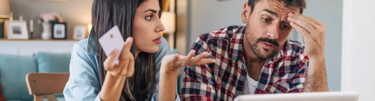 Un couple en train de réfléchir à une solution. Ils regardent l'ordinateur portable.