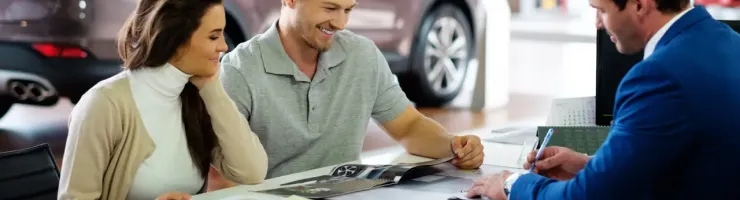 Un couple est en train de choisir un véhicule avec un conseiller automobile