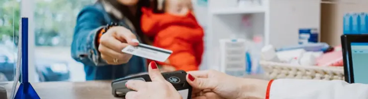 Une femme donne sa carte de mutuelle à une pharmacienne