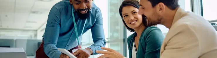 Un couple et un conseiller banciare sont en train d'échanger, le conseiller montre des informations sur une tablette au couple.