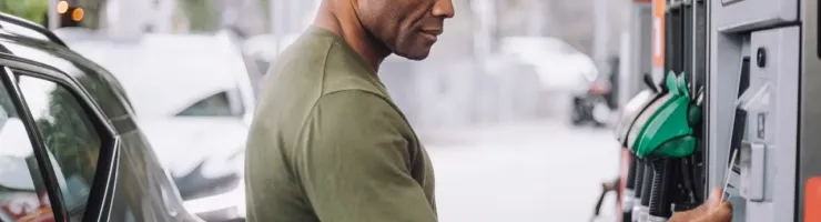 Un homme à une station-service utilise sa carte bancaire pour payer.