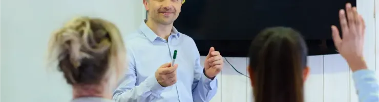 Un instructeur présente un tableau avec des scènes de conduite à des élèves.