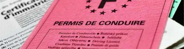 Gros plan sur un permis de conduire français rose vif avec l'inscription "PERMIS DE CONDUIRE".