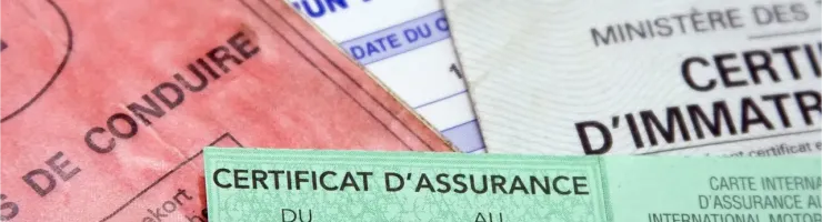 Gros plan sur des documents officiels, dont un "Certificat d'Assurance" vert et un permis de conduire.